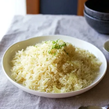 Creamy butter rice served in a bowl with herbs and spices