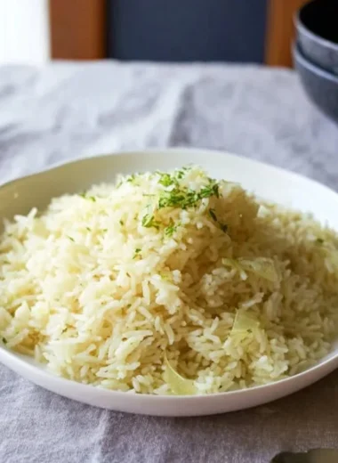Creamy butter rice served in a bowl with herbs and spices