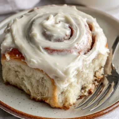 Freshly baked cinnamon rolls with a swirl of cinnamon and icing