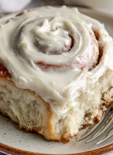 Freshly baked cinnamon rolls with a swirl of cinnamon and icing