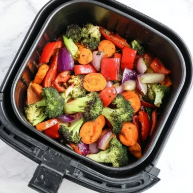 Bowl of easy air fryer roasted vegetables featuring colorful peppers, carrots, and zucchini.