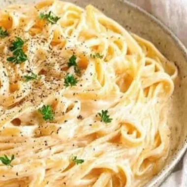 Delicious plate of Fettuccine Alfredo pasta topped with Parmesan cheese.