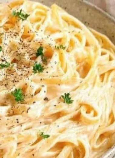 Delicious plate of Fettuccine Alfredo pasta topped with Parmesan cheese.