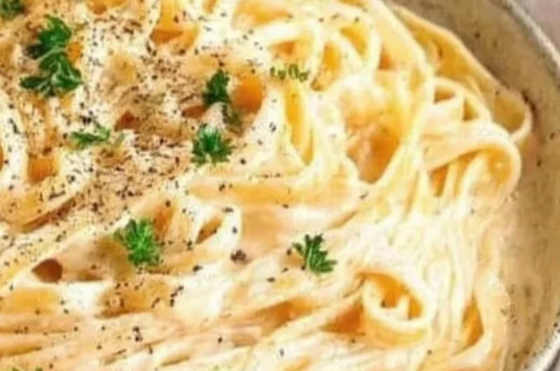 Delicious plate of Fettuccine Alfredo pasta topped with Parmesan cheese.