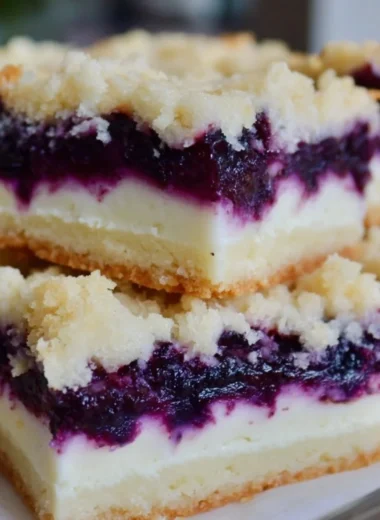 Lemon blueberry shortbread bars garnished with blueberries and lemon zest.
