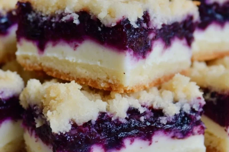 Lemon blueberry shortbread bars garnished with blueberries and lemon zest.