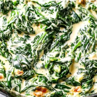 A bowl of creamy spinach with butter and seasoning, ready to serve as a side dish.