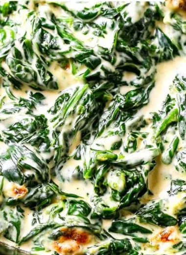 A bowl of creamy spinach with butter and seasoning, ready to serve as a side dish.