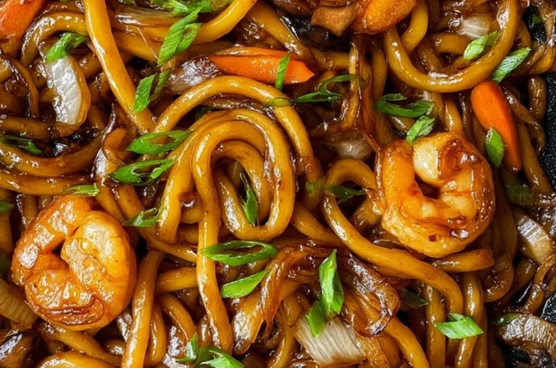 Delicious plate of fried udon noodles with vegetables and sauce