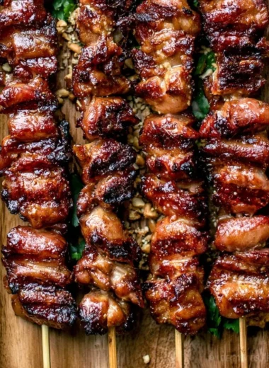 Grilled Thai Coconut Chicken skewers garnished with herbs