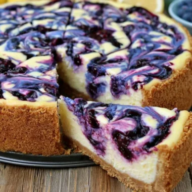 Delicious Lemon Blueberry Cheesecake topped with fresh blueberries and lemon zest.