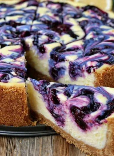 Delicious Lemon Blueberry Cheesecake topped with fresh blueberries and lemon zest.