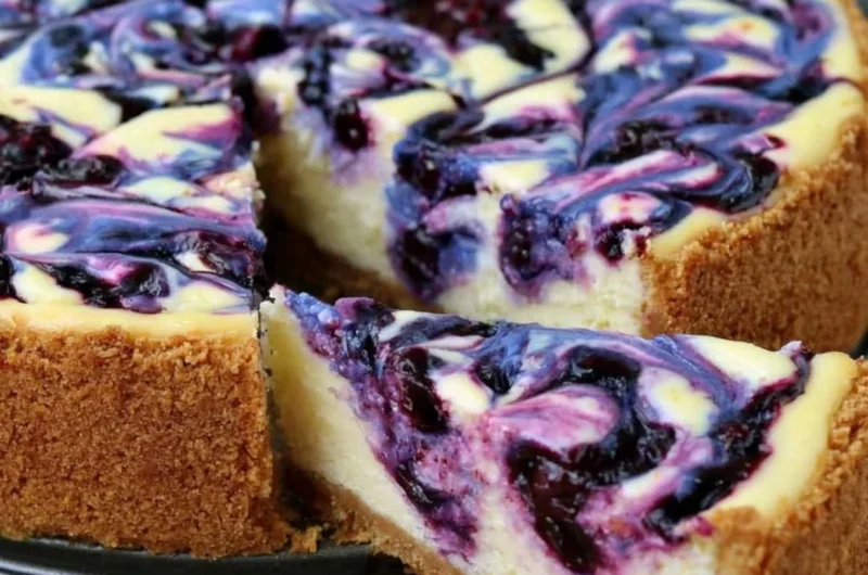 Delicious Lemon Blueberry Cheesecake topped with fresh blueberries and lemon zest.