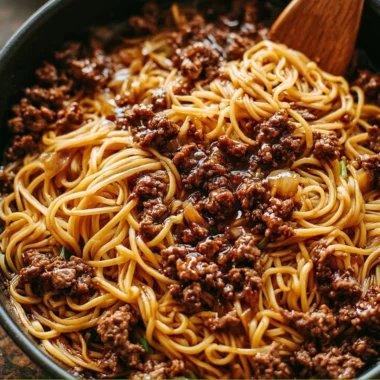 Delicious plate of Mongolian ground beef noodles with vegetables and spices.