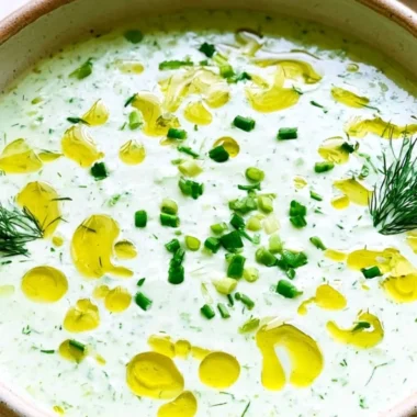 Chilled cucumber gazpacho served in a bowl, garnished with fresh herbs.