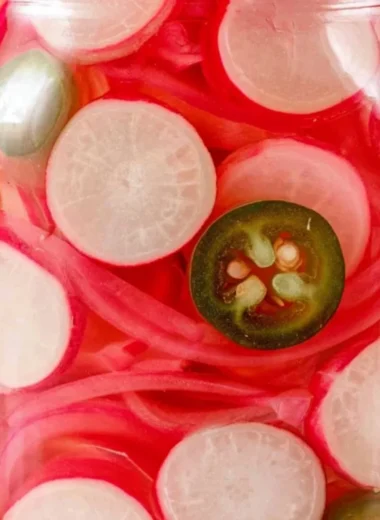 Quick pickled radishes in a jar, perfect for adding flavor to various dishes.