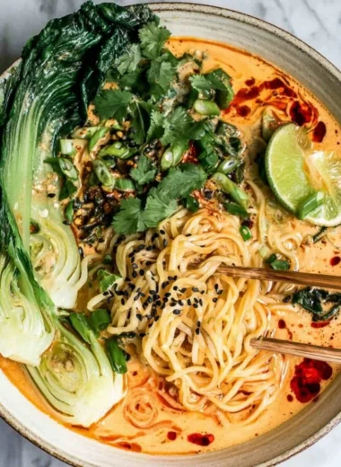 Delicious bowl of quick spicy coconut noodles garnished with fresh herbs