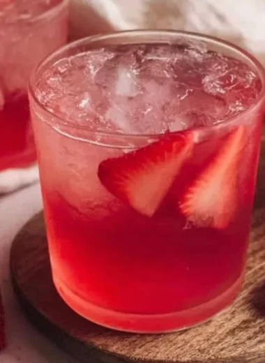 Refreshing strawberry iced tea in a glass with fresh strawberries and mint
