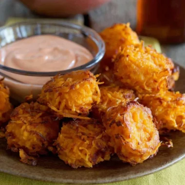 Crispy sweet potato tots served on a plate with dipping sauce