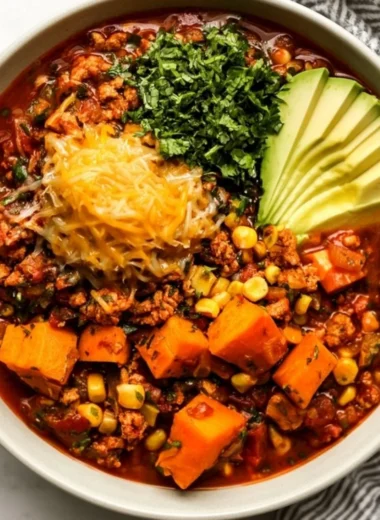 Bowl of hearty sweet potato turkey chili topped with cilantro and avocado.