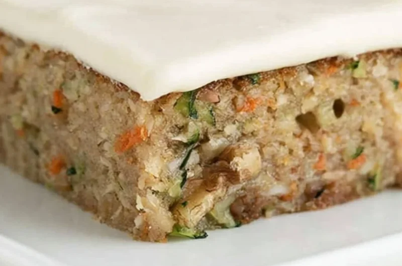 Delicious homemade zucchini bars topped with frosting and served on a plate