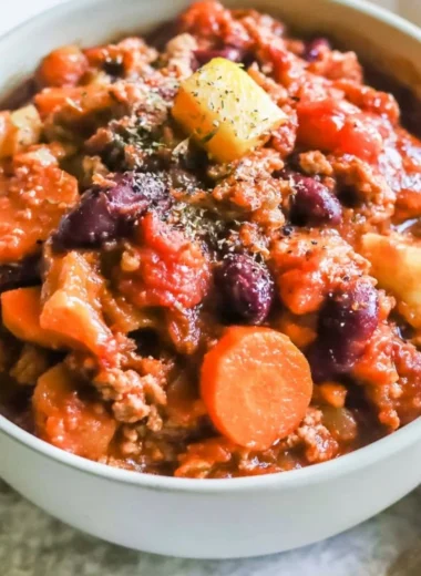 Bowl of Turkey Apple Chili garnished with fresh herbs and served with crusty bread