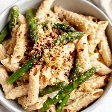 Delicious vegan lemon white bean pasta garnished with herbs.