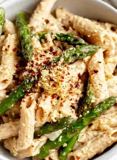 Delicious vegan lemon white bean pasta garnished with herbs.