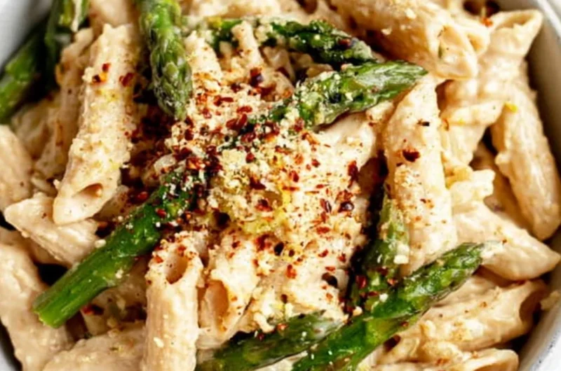 Delicious vegan lemon white bean pasta garnished with herbs.