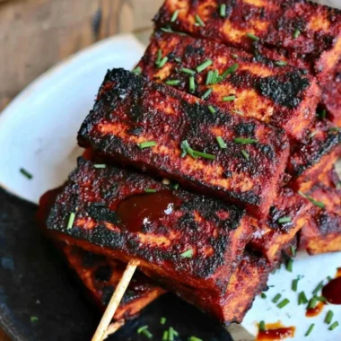 Vegan Sweet and Spicy BBQ Tofu served on a plate with colorful vegetables