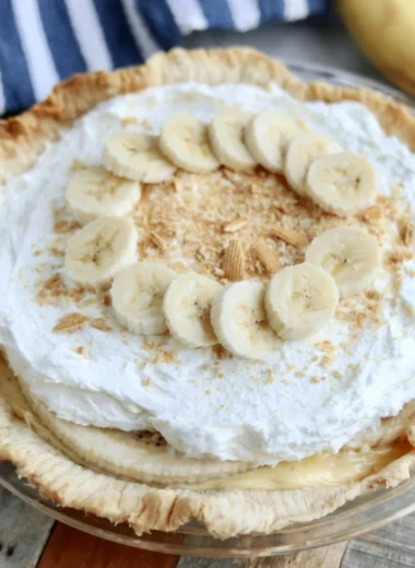 Slice of delicious Banana Cream Pie with whipped cream and fresh bananas