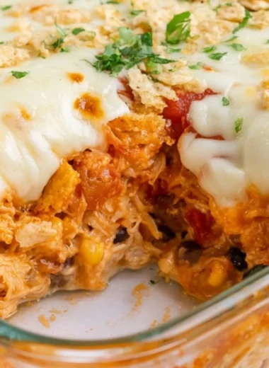 Cozy Cheesy Chicken Taco Casserole with layers of cheese and toppings