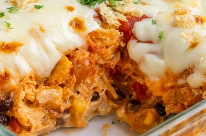 Cozy Cheesy Chicken Taco Casserole with layers of cheese and toppings