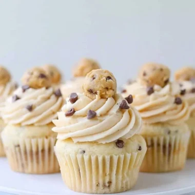 Cozy cookie dough cupcakes topped with creamy frosting and cookie pieces.