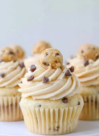 Cozy cookie dough cupcakes topped with creamy frosting and cookie pieces.