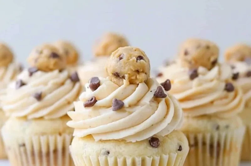 Cozy cookie dough cupcakes topped with creamy frosting and cookie pieces.