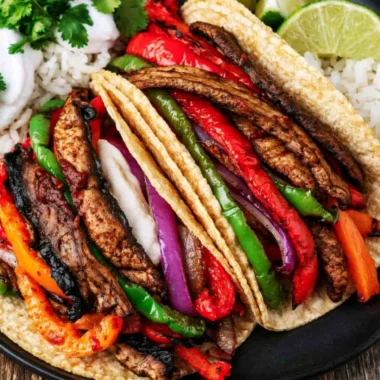 Cozy Portobello vegan fajitas served with colorful peppers and onions.