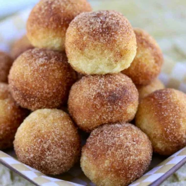 A plate of soft and fluffy sourdough doughnuts topped with glaze and sprinkles.