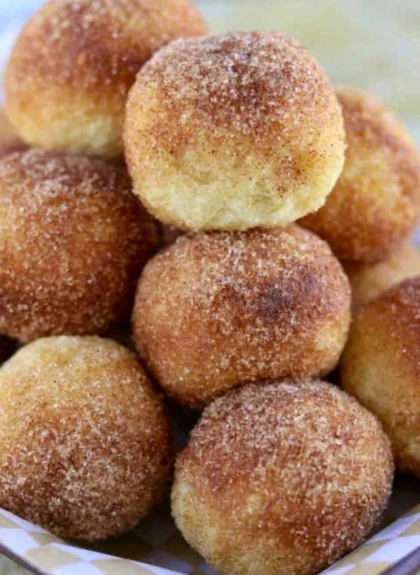 A plate of soft and fluffy sourdough doughnuts topped with glaze and sprinkles.