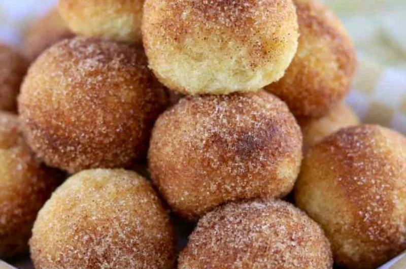 A plate of soft and fluffy sourdough doughnuts topped with glaze and sprinkles.