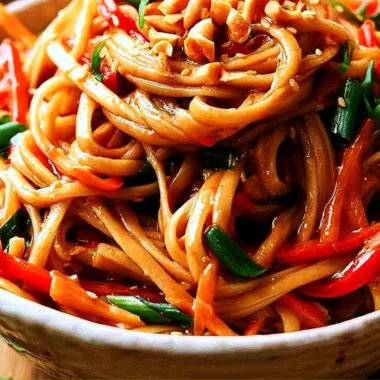 Plated easy Thai noodles topped with peanut sauce and fresh vegetables