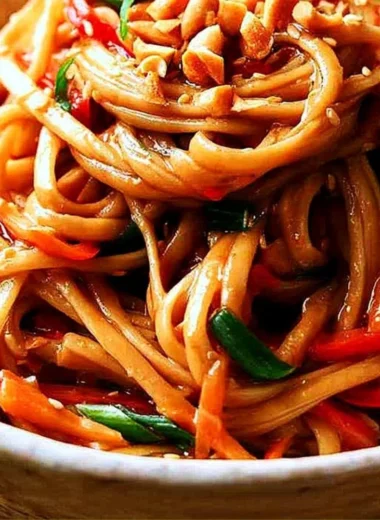 Plated easy Thai noodles topped with peanut sauce and fresh vegetables