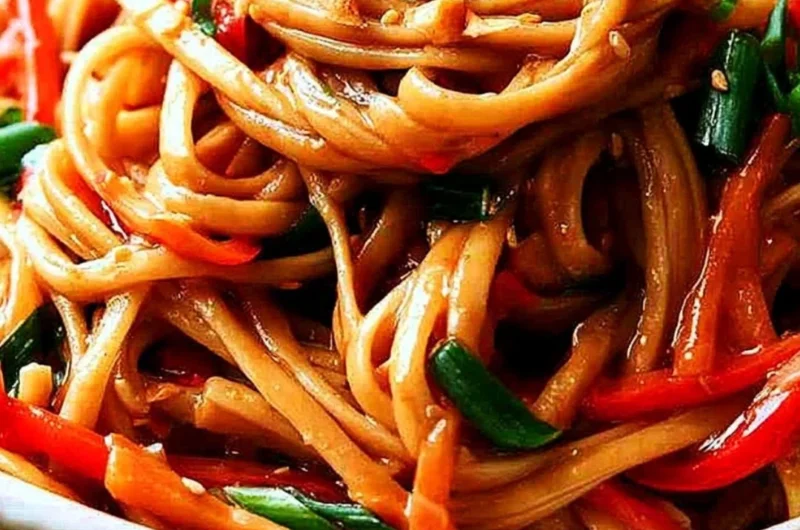 Plated easy Thai noodles topped with peanut sauce and fresh vegetables