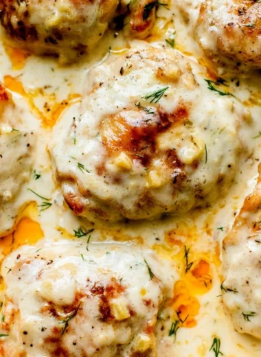 Creamy oven baked chicken thighs served on a plate with herbs and sides