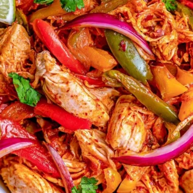 Savory crockpot chicken fajitas served in a bowl with colorful vegetables.