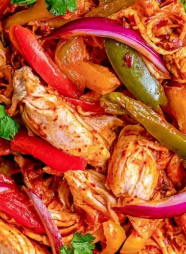 Savory crockpot chicken fajitas served in a bowl with colorful vegetables.