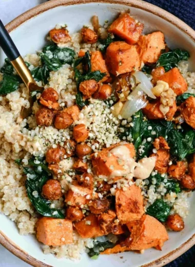 Vegan sweet potato grain bowl with almond dressing and fresh vegetables